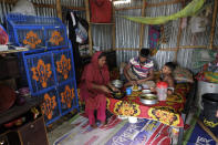 Mohammad Jewel and Arzu Begum have a meal in their home with their son Arman in the poor Mirpur area of Dhaka, Bangladesh on July 24, 2022. Jewel and Begum were forced to flee Ramdaspur village in Bangladesh last year when the Meghna River flooded and destroyed their home. The couple and their four sons moved to the capital, Dhaka, where they struggle to pay their rent and food bills on their small incomes. (AP Photo/Mahmud Hossain Opu)