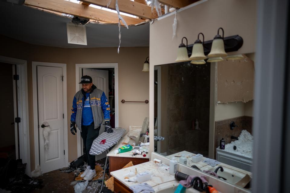 Roosevelt Bozeman checks on the damage to his Clarksville home on Sunday. Tornadoes struck Middle Tennessee on Saturday, killing at least six people and leaving more than 160,000 Middle Tennessee residents without power.