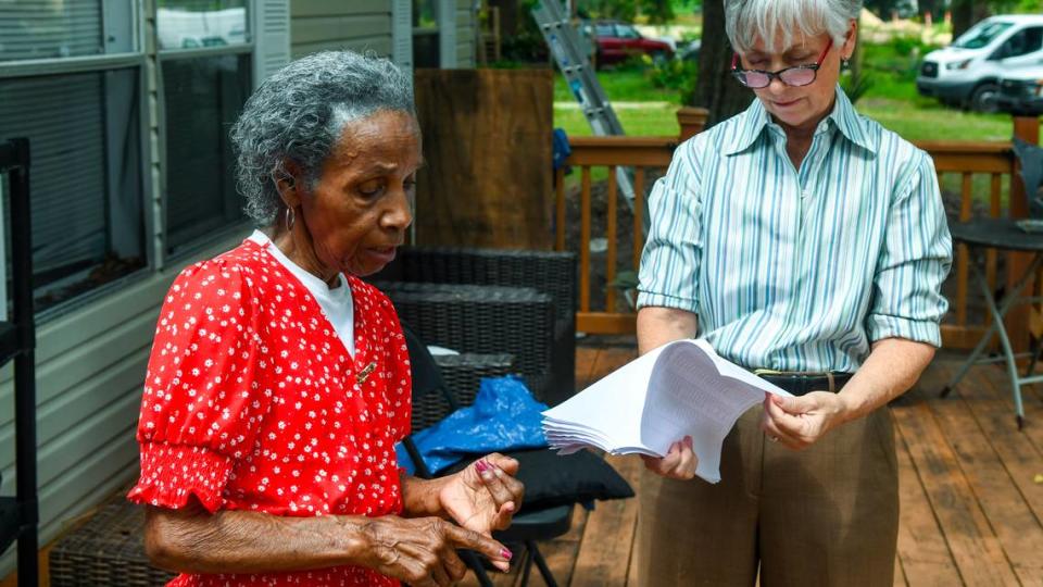 Josephine Wright lists her relatives, including her son, that are buried in Elliott Cemetery, a Gullah graveyard located behind the gates of Hilton Head Plantation on June 9, 2023 as Kelly LeBlanc looks over a gravesite records. Wright is currently fighting to keep her land that family says has been in their name since around the end of the Civil War.