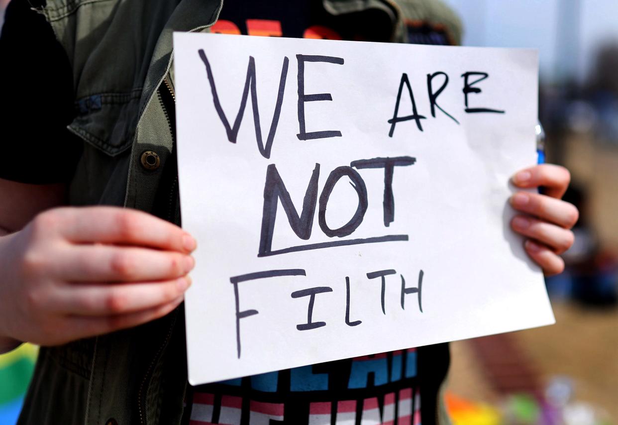 Max (who asked that their last name not be used out of safety concerns) holds a sign on Feb. 26 at Owasso High School.