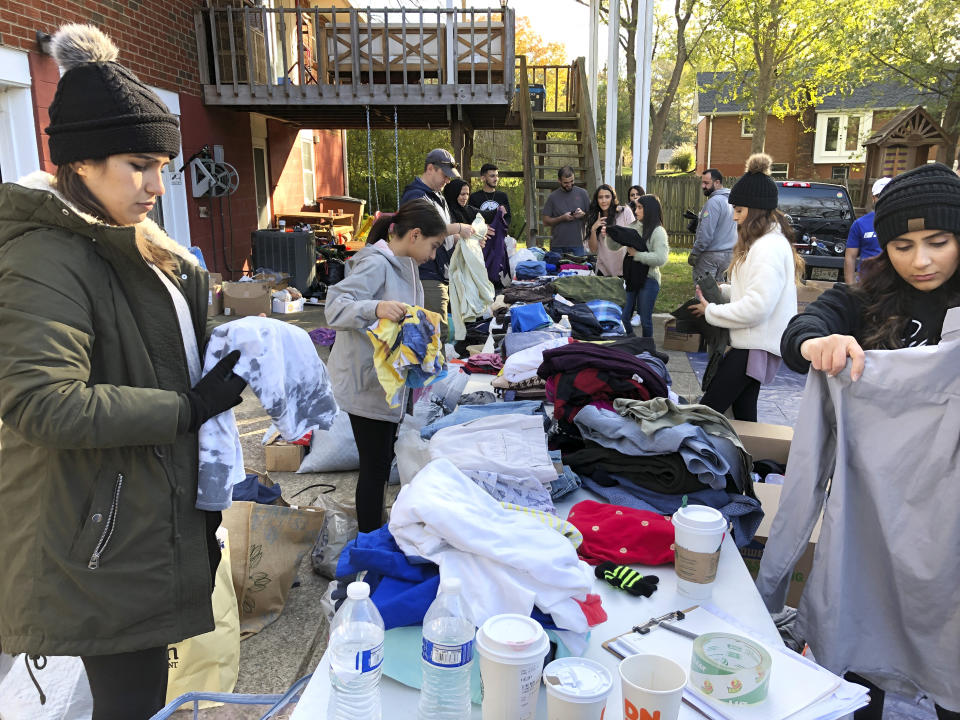 In this Nov. 9, 2019, photo, members of the Kurdish community and supporters pack clothing donations in Nashville, Tenn. The items are being sent to a camp in Iraq where many Kurds have fled from Syria. Nashville lays claim to the largest diaspora of Kurds in the U.S., and many of them say President Donald Trump betrayed the Kurdish people through the withdrawal of troops from northern Syria. (AP Photo/Jonathan Mattise)