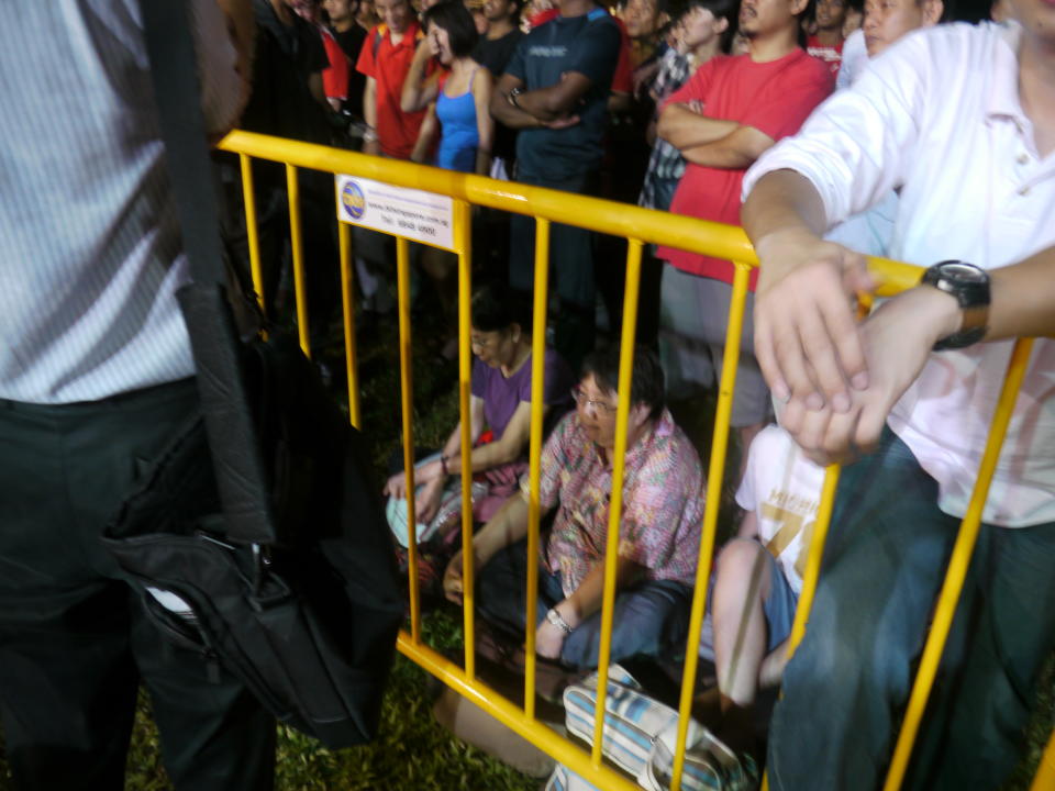 Some of the spectators chose to sit down after standing for too long at the SDP rally on Thursday, 28 April. (Yahoo! photo/ Faris Mokhtar). 