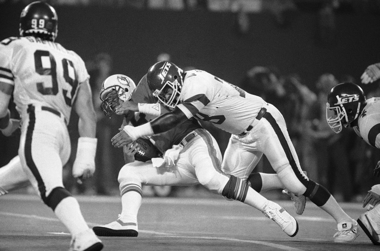 New York Jets lineman Barry Bennett tackles Miami Dolphins quarterback Dan Marino in 1985.