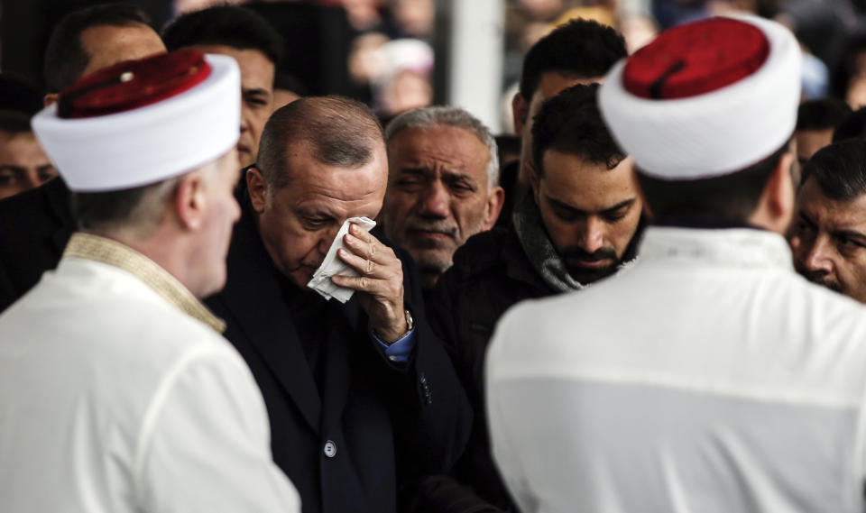 Turkey's President Recep Tayyip Erdogan, center, reacts as he joins hundreds of mourners who attend the funeral prayers for nine members of Alemdar family killed in a collapsed apartment building, in Istanbul, Saturday, Feb. 9, 2019. Erdogan says there are "many lessons to learn" from the collapse of a residential building in Istanbul where at least 17 people have died.(AP Photo/Emrah Gurel)