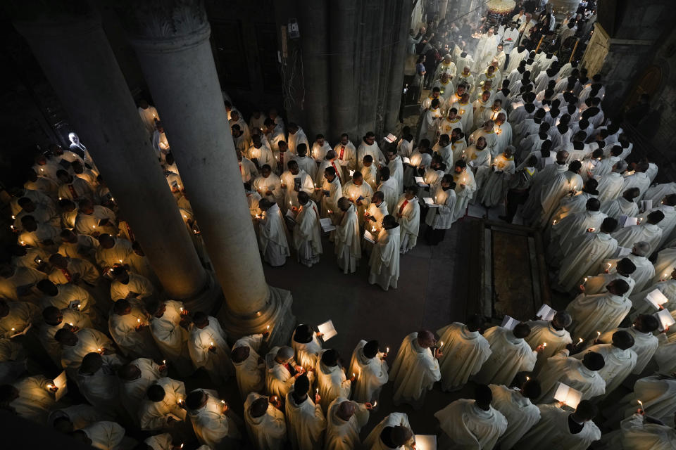 Catholic clergy hold candles as they walk during the Washing of the Feet procession at the Church of the Holy Sepulcher, where many Christians believe Jesus was crucified, buried, and rose from the dead, in the Old City of Jerusalem, Thursday, March 28, 2024. (AP Photo/Ohad Zwigenberg)