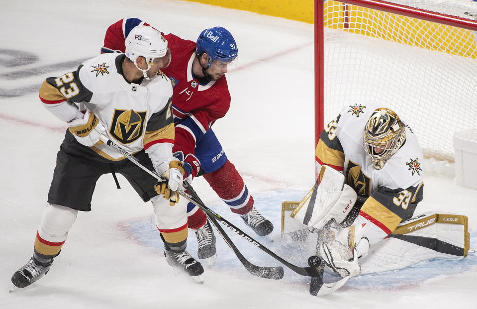 Montreal Canadiens' Sean Monahan (91) moves in on Vegas Golden Knights goaltender Adin Hill as Golden Knights' Alec Martinez (23) defends during the second period of an NHL hockey game Saturday, Nov. 5, 2022, in Montreal. (Graham Hughes/The Canadian Press via AP)
