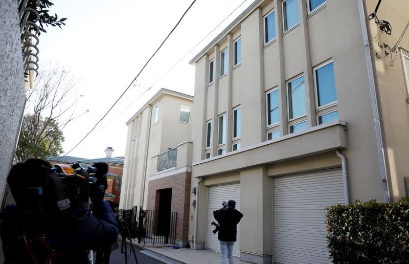 A TV cameraman films exterior of the Tokyo residence of former Nissan chairman Carlos Ghosn while prosecutors raid the house in Tokyo