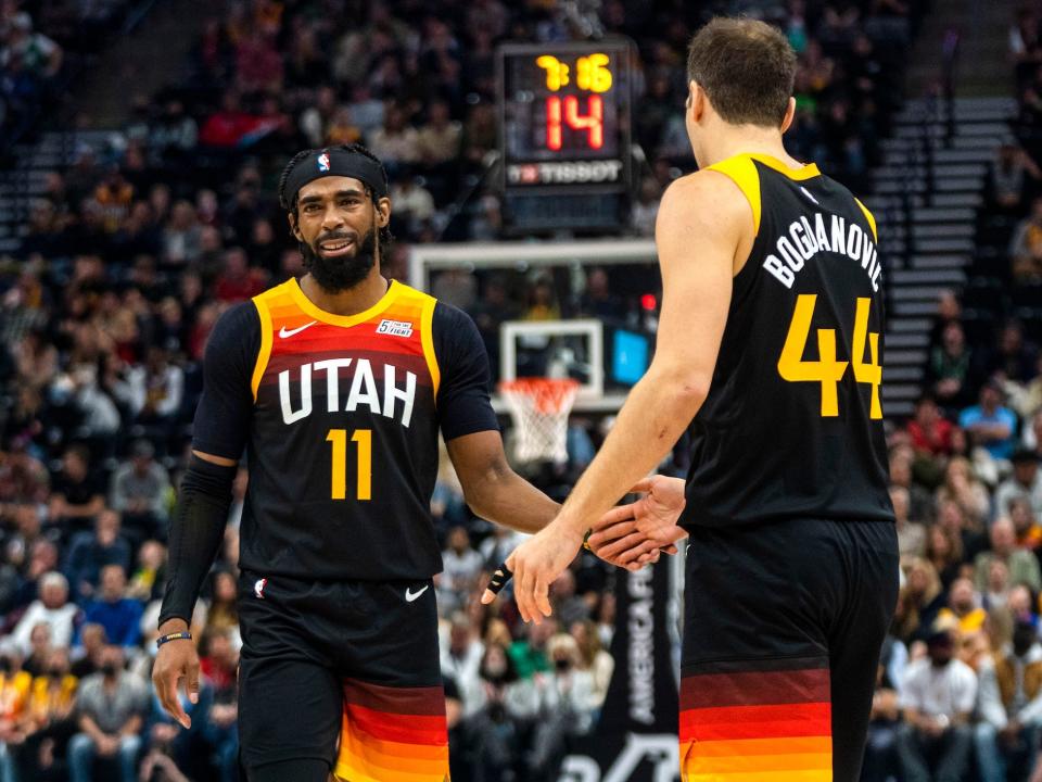 Mike Conley high-fives Bojan Bogdanovic during a game in 2021.