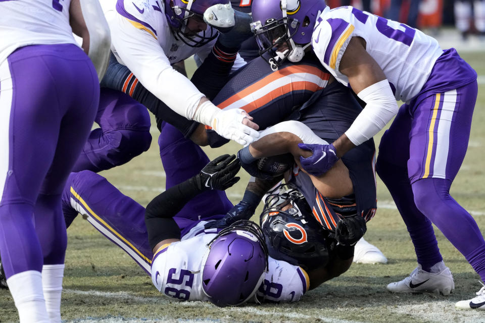 Chicago Bears running back David Montgomery, center, is tackled by Minnesota Vikings linebacker Jordan Hicks (58) during the first half of an NFL football game, Sunday, Jan. 8, 2023, in Chicago. (AP Photo/Charles Rex Arbogast)