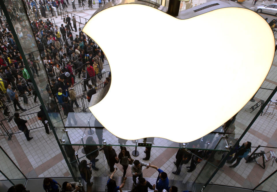 FILE - In this Saturday, Oct. 20, 2012, file photo, employees cheer customers as they enter a newly-opened Apple Store in the Wangfujing shopping district in Beijing. Google, Apple, Intel and Adobe Systems announced Thursday, April 24, 2014, they have settled a class-action lawsuit alleging they conspired to prevent their engineers and other highly sought technology workers from getting better job offers from one another. (AP Photo/Andy Wong, File)