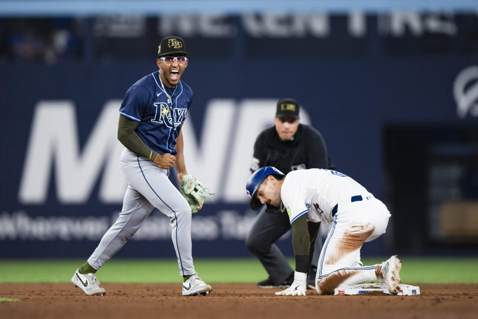 Tampa Bay Rays second baseman Richie Palacios, left, reacts after Toronto Blue Jays' Cavan Biggio, front right, was forced out on a double play during the eighth inning of a baseball game in Toronto, Friday, May 17, 2024. (Christopher Katsarov/The Canadian Press via AP)