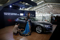 A model has her dress adjusted as she poses next to a BMW 7 Series car assembled locally during a media launch at a Gaya Motor assembly plant in Jakarta, Indonesia November 30, 2016. REUTERS/Darren Whiteside