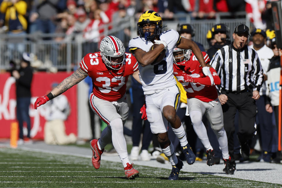 Michigan receiver Cornelius Johnson, front, outruns Ohio State defenders Cameron Brown, right, and Brenten Jones to score a touchdown during the first half of an NCAA college football game on Saturday, Nov. 26, 2022, in Columbus, Ohio. (AP Photo/Jay LaPrete)