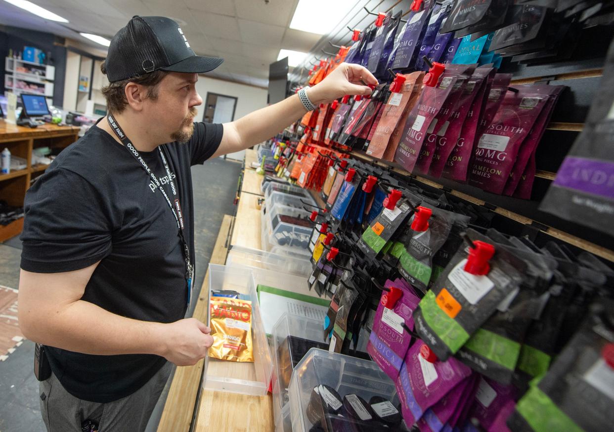 Thomas Walker of Terry, Miss., restocks merchandise at Uptown Funk dispensary in Jackson on Thursday, April 18, 2024. It’s been more than a year since the first legal sale of medical marijuana in the state.