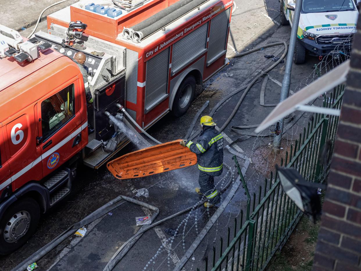 A member of the Johannesburg Emergency Services cleans a stretcher at the scene (AFP via Getty Images)