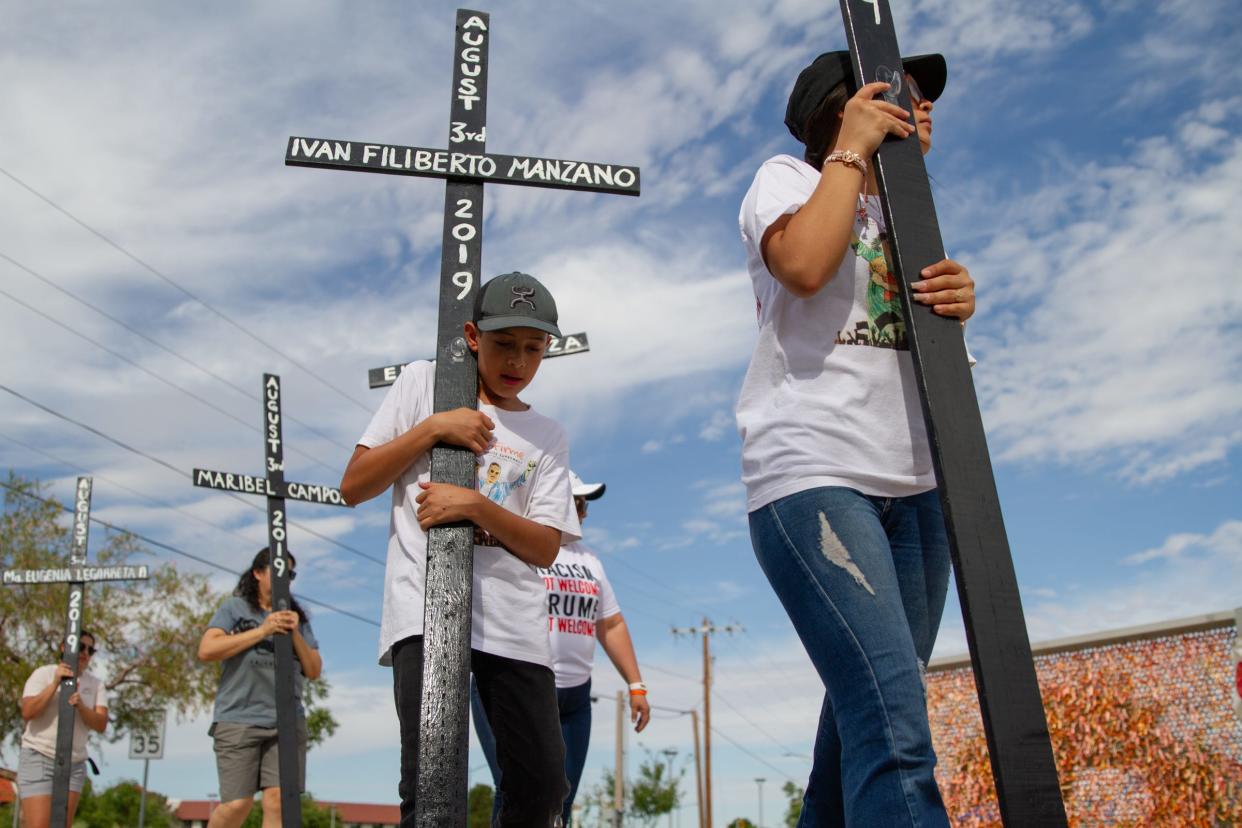 A young boy carries a cross to Ponder Park where a vigil is held on Aug. 3, 2023 for the fourth anniversary of the Aug. 3, 2019 mass shooting take took place inside a Walmart in El Paso, Texas