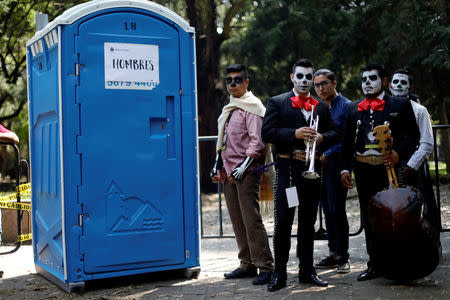 Mariachis characterised as "The Elegant Death" wait to enter bathroom before taking part in a procession to commemorate Day of the Dead in Mexico City, Mexico, October 28, 2017. REUTERS/Edgard Garrido