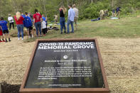 Various groups affected by the global coronavirus pandemic gather to plant trees on April 30, 2021, at Ohio's dedication of a new COVID-19 Pandemic Memorial Grove at Great Seal State Park near Chillicothe, Ohio. The country has begun finding ways to remember the more than 600,000 Americans who have died from the coronavirus, but the process is fraught compared to past memorial drives because of the politics. (AP Photo/Julie Carr Smyth)