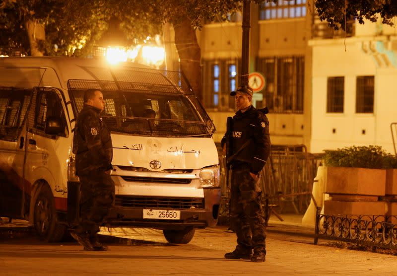 Police officers stand guard near the interior ministry in Tunis