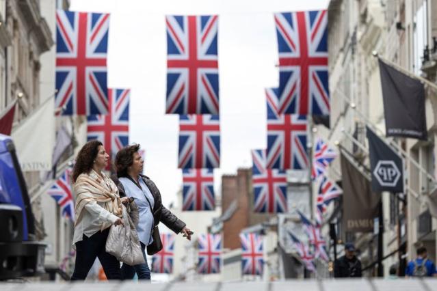 Women walk on a street, a day after Britain's King Charles and Queen Camilla's coronation ceremony, in London