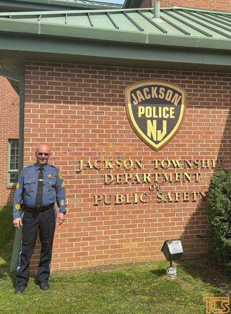 Police Sgt. Joseph Candido, center, poses outside the Jackson Township public safety office after being named the township's public safety director on April 10, 2024.