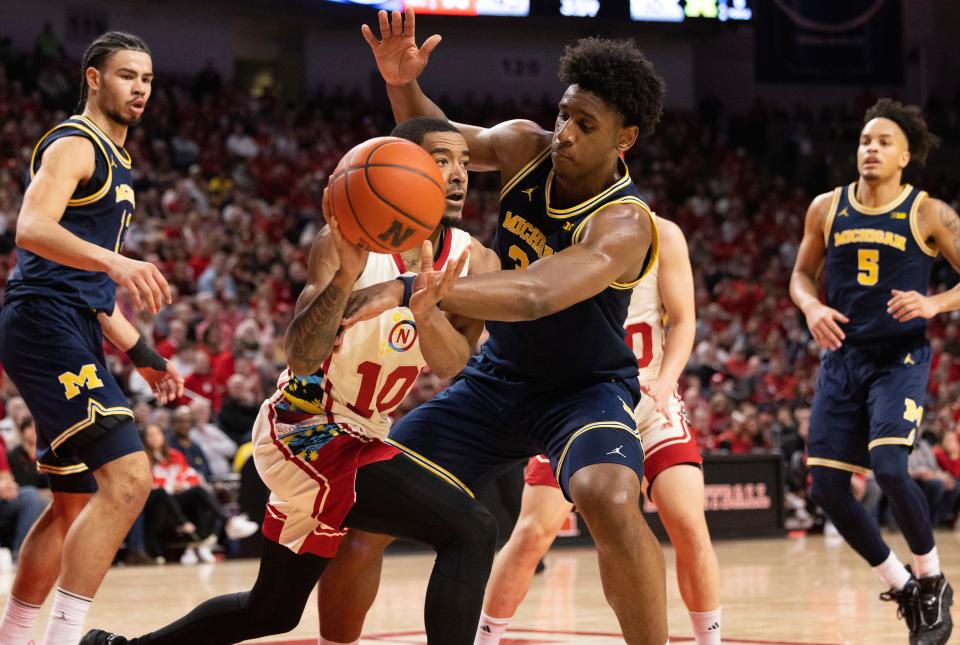Nebraska's Jamarques Lawrence, center left, passes the ball around Michigan's Tarris Reed Jr., center right, during the first half at Pinnacle Bank Arena in Lincoln, Nebraska, on Saturday, Feb. 10, 2024.