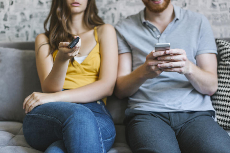 a couple watching tv and being on their phone