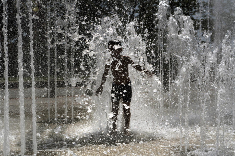 A child plays in a fountain in Lyon, central France, Wednesday, June 26, 2019. High temperatures are expected to go up to 39 degrees Celsius (102 Fahrenheit) later this week. (AP Photo/Laurent Cipriani)