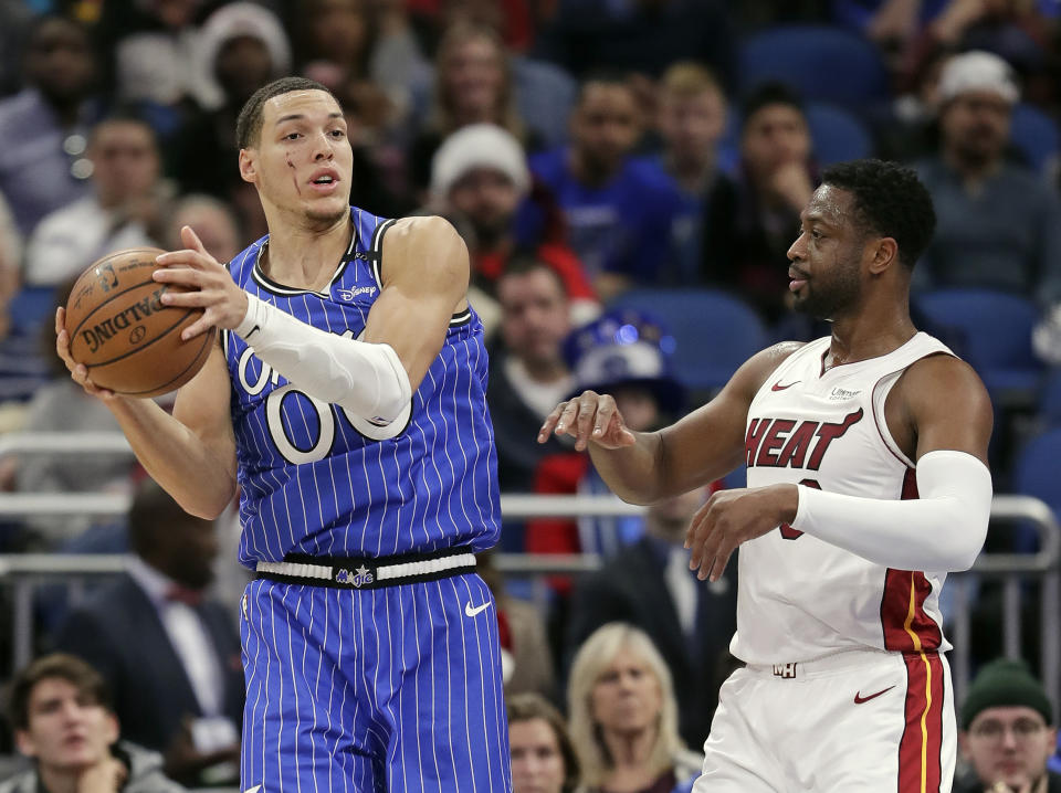 Orlando Magic's Aaron Gordon, left, looks to pass as he is defended by Miami Heat's Dwyane Wade during the first half of an NBA basketball game, Sunday, Dec. 23, 2018, in Orlando, Fla. (AP Photo/John Raoux)