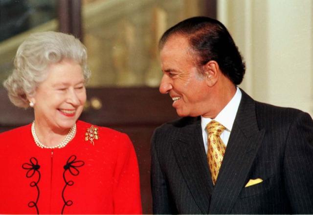 Su majestad la reina Isabel II y el expresidente Carlos Menem sonrien durante el encuentro en el Palacio de Buckingham, donde el jefe de estado argentino fue agasajado con un almuerzo en su honor, el 28 de noviembre de 1998