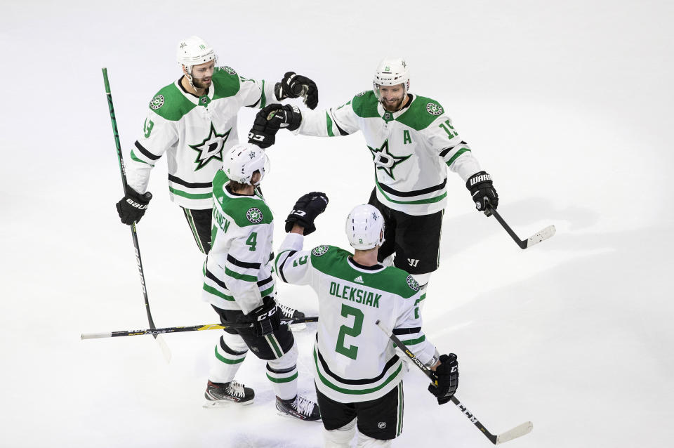 Dallas Stars' Jason Dickinson (18), Blake Comeau (15), Miro Heiskanen (4) and Jamie Oleksiak (2) celebrate a goal against the Colorado Avalanche during first-period NHL Western Conference Stanley Cup playoff hockey game action in Edmonton, Alberta, Saturday, Aug. 22, 2020. (Jason Franson/The Canadian Press via AP)