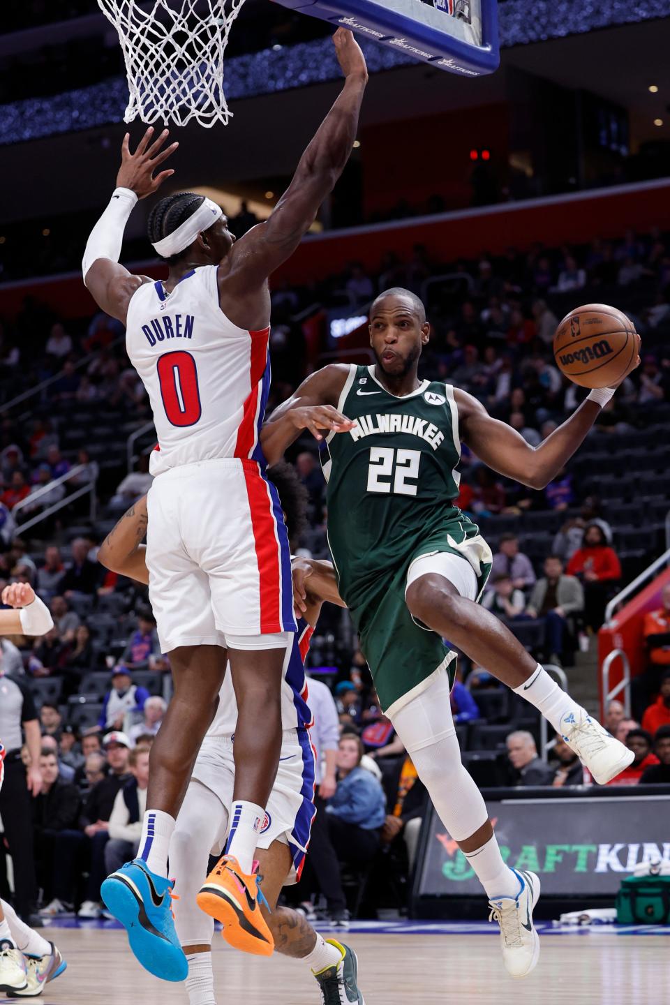 Bucks forward Khris Middleton passes around Pistons center Jalen Duren  in the second half Monday night at Little Caesars Arena.