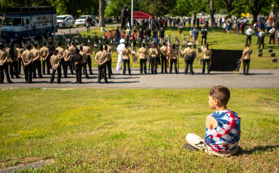 Logan Sullivan, 6, watches the city’s Memorial Day ceremony in Hope Cemetery Monday.