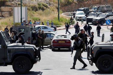 Israeli security forces gather at the scene where a female Palestinian was shot dead by Israeli troops at the entrance to Kiryat Arba near the West Bank city of Hebron June 24, 2016. REUTERS/Mussa Qawasma