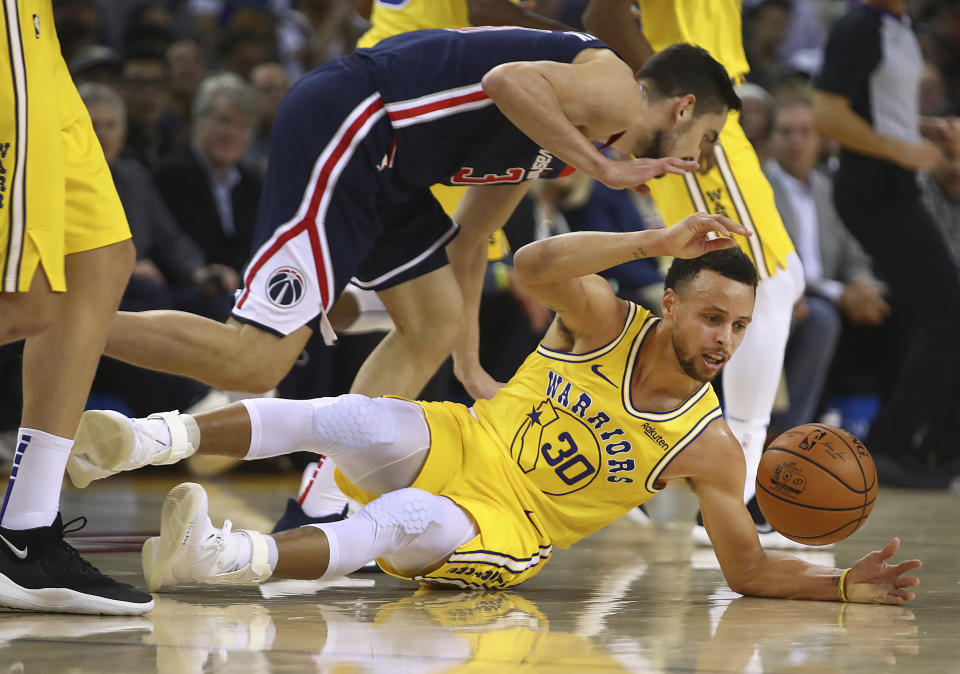 Golden State Warriors' Stephen Curry (30) recovers the ball in front of Washington Wizards' Tomas Satoransky during the first half of an NBA basketball game Wednesday, Oct. 24, 2018, in Oakland, Calif. (AP Photo/Ben Margot)