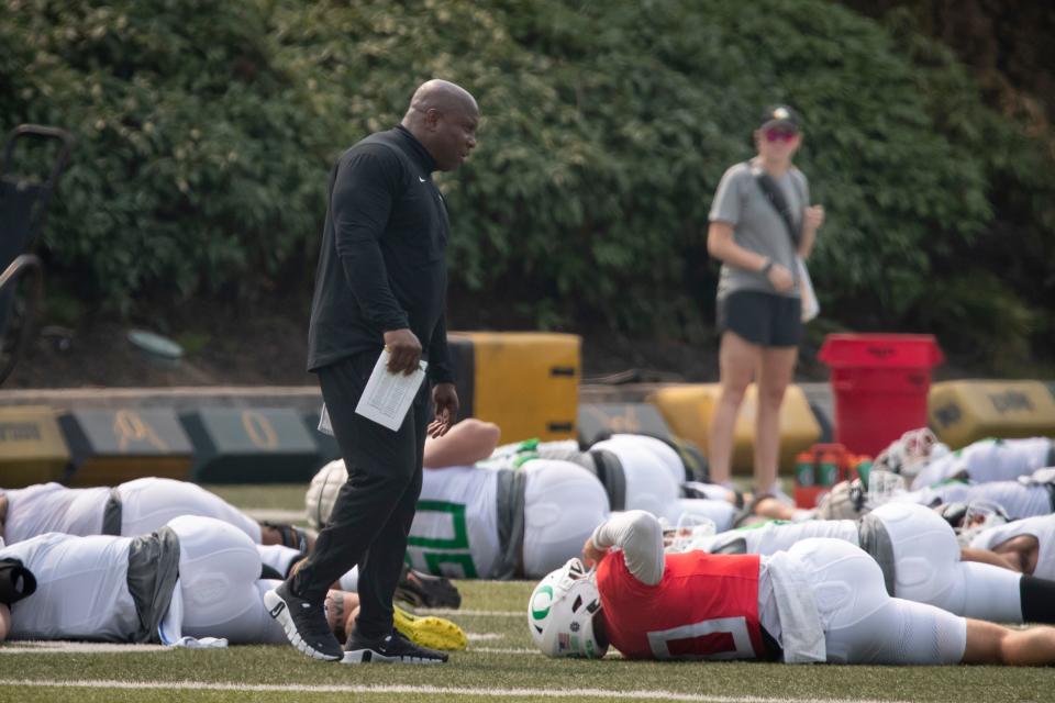 Oregon running backs coach Carlos Locklyn walks the field during practice with the Ducks Wednesday, Aug. 16, 2023.