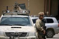 U.S army soldier holds a gun as he stands guard next to an armoured vehicle as Brett McGurk, U.S. envoy to the coalition against Islamic State, visits the town of Tabqa, Syria June 29, 2017. REUTERS/Rodi Said/Files