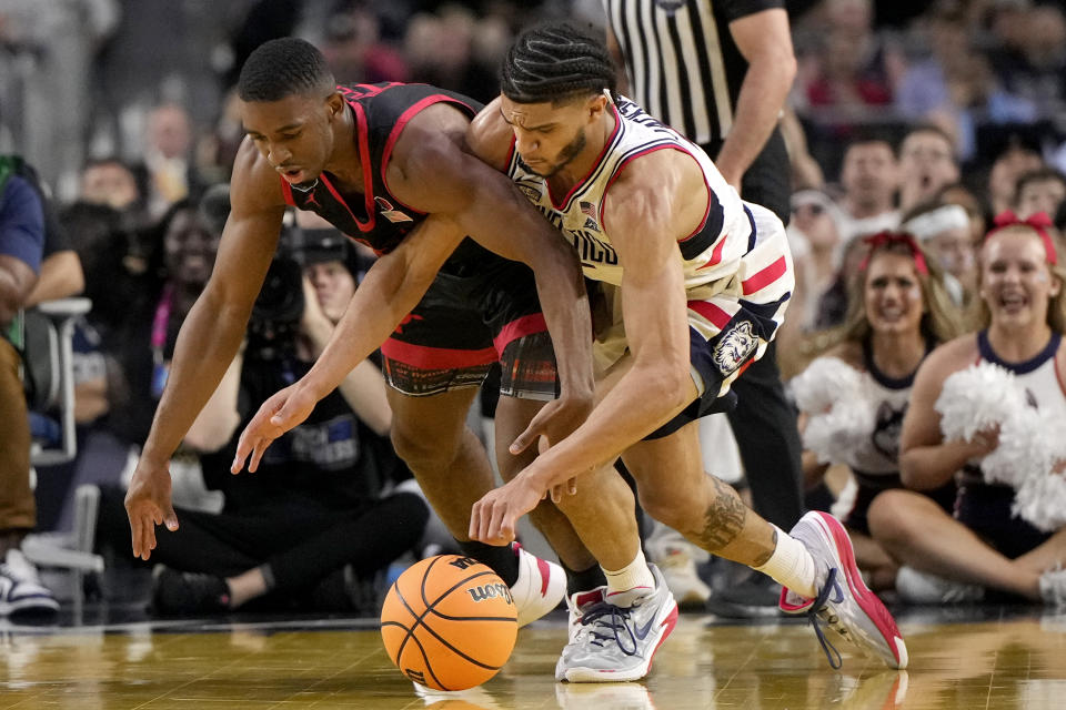 San Diego State guard Lamont Butler, left, and Connecticut guard Andre Jackson Jr. vie for a loose ball during the first half of the men's national championship college basketball game in the NCAA Tournament on Monday, April 3, 2023, in Houston. (AP Photo/David J. Phillip)