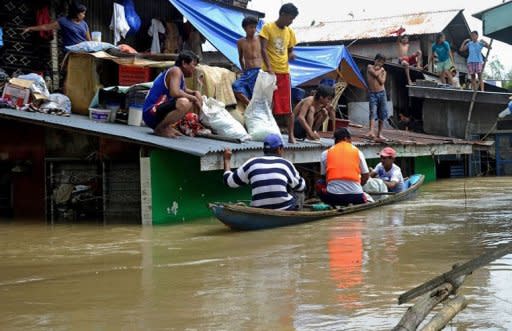 Residents sit marooned on their rooftops after Typhoon Nalgae flooded the town of Calumpit, an agricultural town about two hours north of the capital Manila. The Philippines deployed helicopters, inflatable boats and amphibious vehicles Sunday in a desperate bid to evacuate tens of thousands in the aftermath of successive monster storms