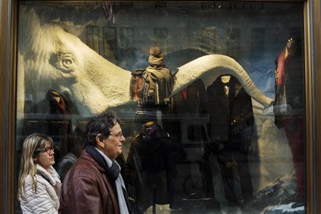 Pedestrians walk past the holiday window displays of the Bergdorf Goodman store in New York, November 22, 2013. REUTERS/Lucas Jackson