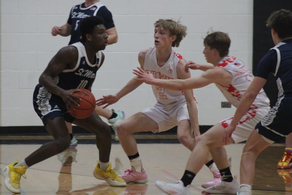 Onaway seniors Jadin Mix (middle) and Jackson Chaskey (right) trap Gaylord St. Mary's Rylan Matelski during Wednesday's boys basketball game in Onaway.