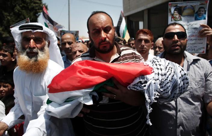 Relatives carry the body of 18-month-old Palestinian toddler Ali Saad Dawabsha, who died after his house was set on fire by Jewish settlers, during his funeral in the West Bank village of Duma on July 31, 2015 (AFP Photo/Thomas Coex)