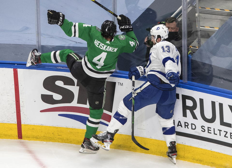 Tampa Bay Lightning center Cedric Paquette (13) checks Dallas Stars defenseman Miro Heiskanen (4) during the second period of Game 3 of the NHL hockey Stanley Cup Final, Wednesday, Sept. 23, 2020, in Edmonton, Alberta. (Jason Franson/The Canadian Press via AP)