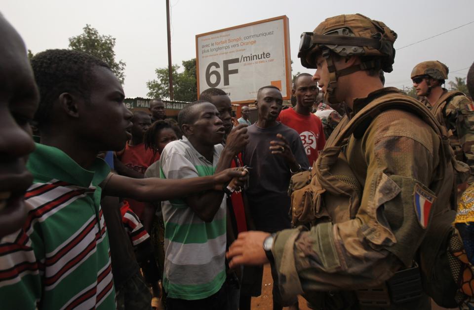 Angry young men complain to French soldiers in patrol in the pro-Christian area of Bangui February 15, 2014. France said on Friday it plans to send another 400 troops to help combat a crisis in the Central African Republic as U.N. chief Ban Ki-moon pleaded for more swift, robust international help to stop sectarian violence that could turn into a genocide. REUTERS/Luc Gnago (CENTRAL AFRICAN REPUBLIC - Tags: POLITICS CIVIL UNREST MILITARY TPX IMAGES OF THE DAY)