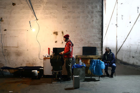 A migrant cuts another's hair in a migrant camp in Bihac, Bosnia and Herzegovina, December 14, 2018. REUTERS/Antonio Bronic