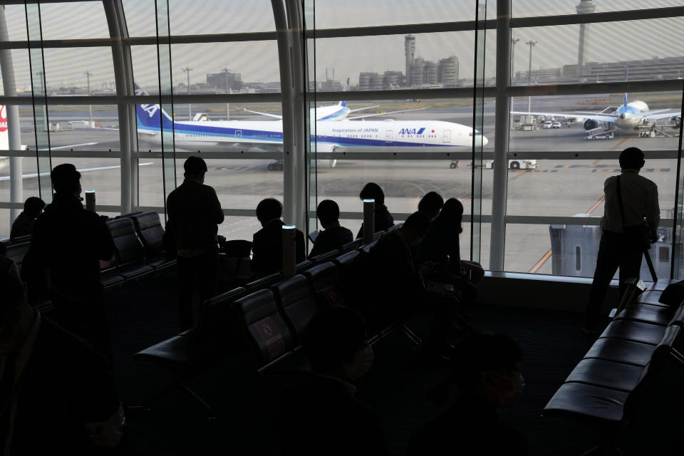 Journalists look at an airplane which Japan's former Princess Mako, the elder daughter of Crown Prince Akishino, and her husband Kei Komuro, are on board to New York Sunday, Nov. 14, 2021, at Tokyo International Airport in Tokyo. (AP Photo/Eugene Hoshiko)