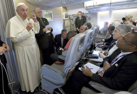 Pope Francis gestures during a meeting with the media onboard the papal plane while en route to Rome, Italy, November 30, 2015. REUTERS/Daniel Dal Zennaro/Pool/File Photo
