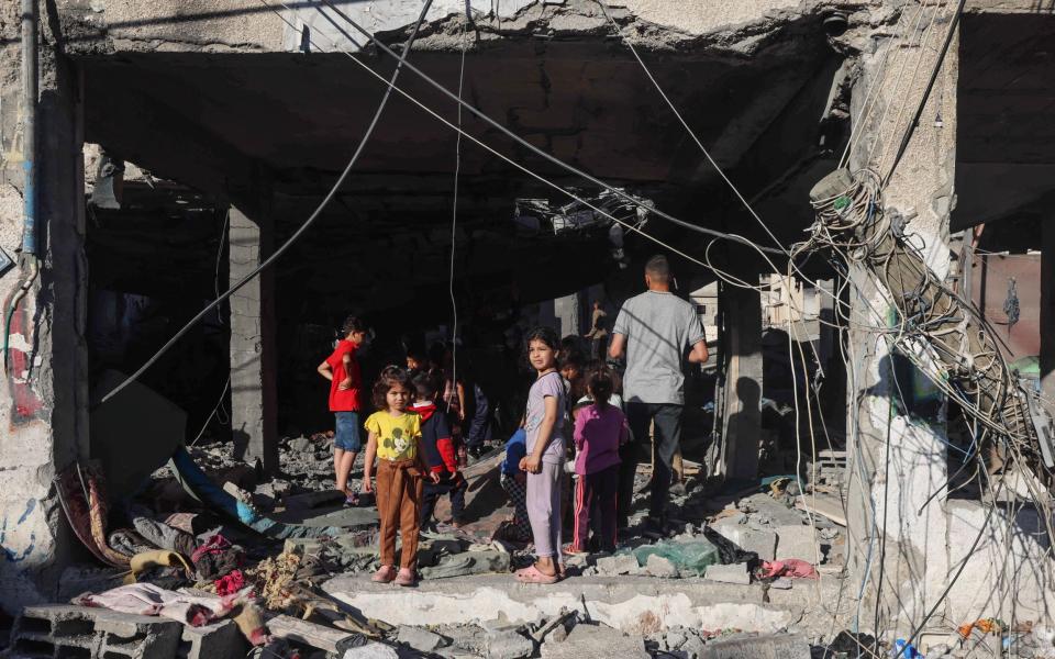 Palestinian children check a building destroyed by Israeli bombardment overnight