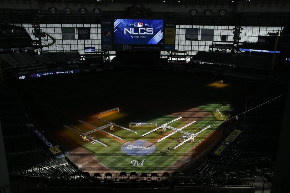 Workers get Miller Park ready for Game 1 of the National League Championship Series baseball game Thursday, Oct. 11, 2018, in Milwaukee. The Milwaukee Brewers play the Los Angeles Dodgers on Friday, Oct. 12, 2018. (AP Photo/Charlie Riedel)