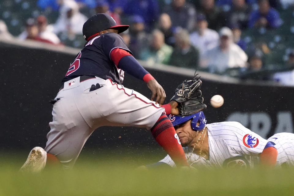 Chicago Cubs' Willson Contreras, right, slides in to second as Washington Nationals second baseman Josh Harrison waits for the throw during the third inning of a baseball game Tuesday, May 18, 2021, in Chicago. Contreras was originally ruled safe with a steal, but the call was overturned on review. (AP Photo/Charles Rex Arbogast)